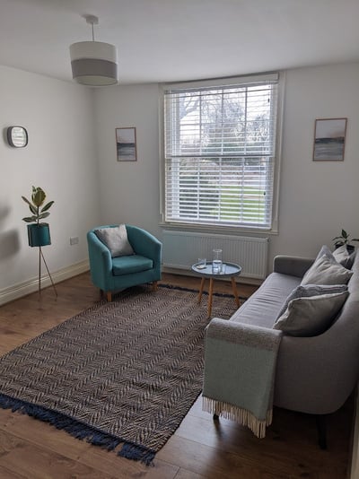 a living room with a couch, chair and table -  church street therapy room 